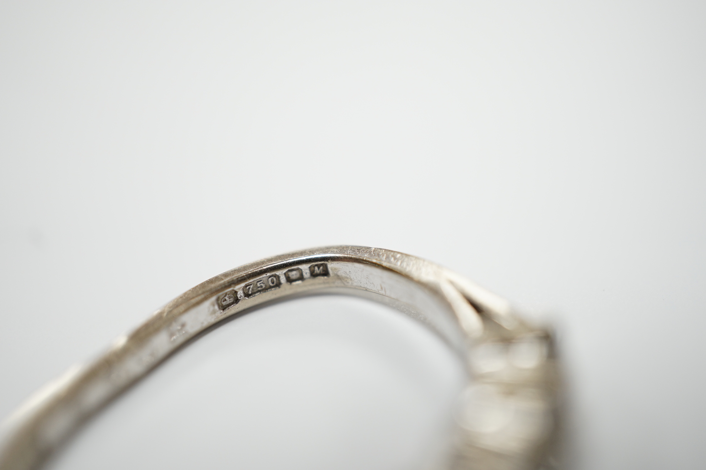 A modern 18ct white gold and six stone diamond set half hoop ring, (shank slightly crushed), gross weight 3.4 grams.